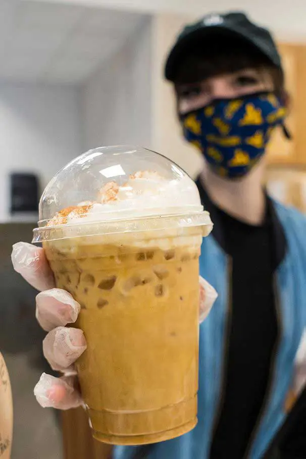 Barista holding up iced coffee