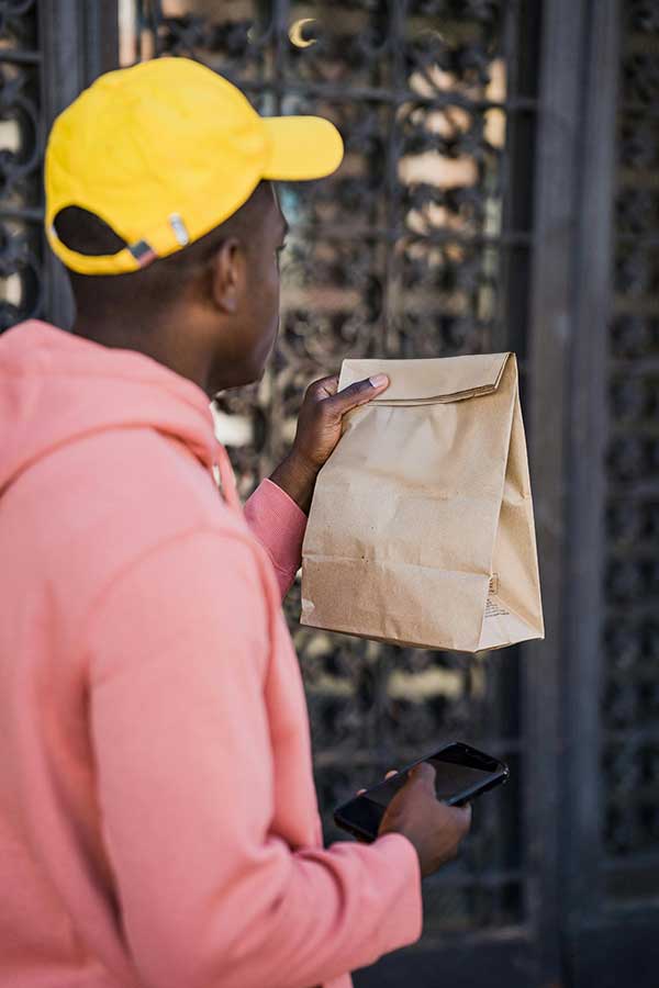 Person holding up brown paper bag
