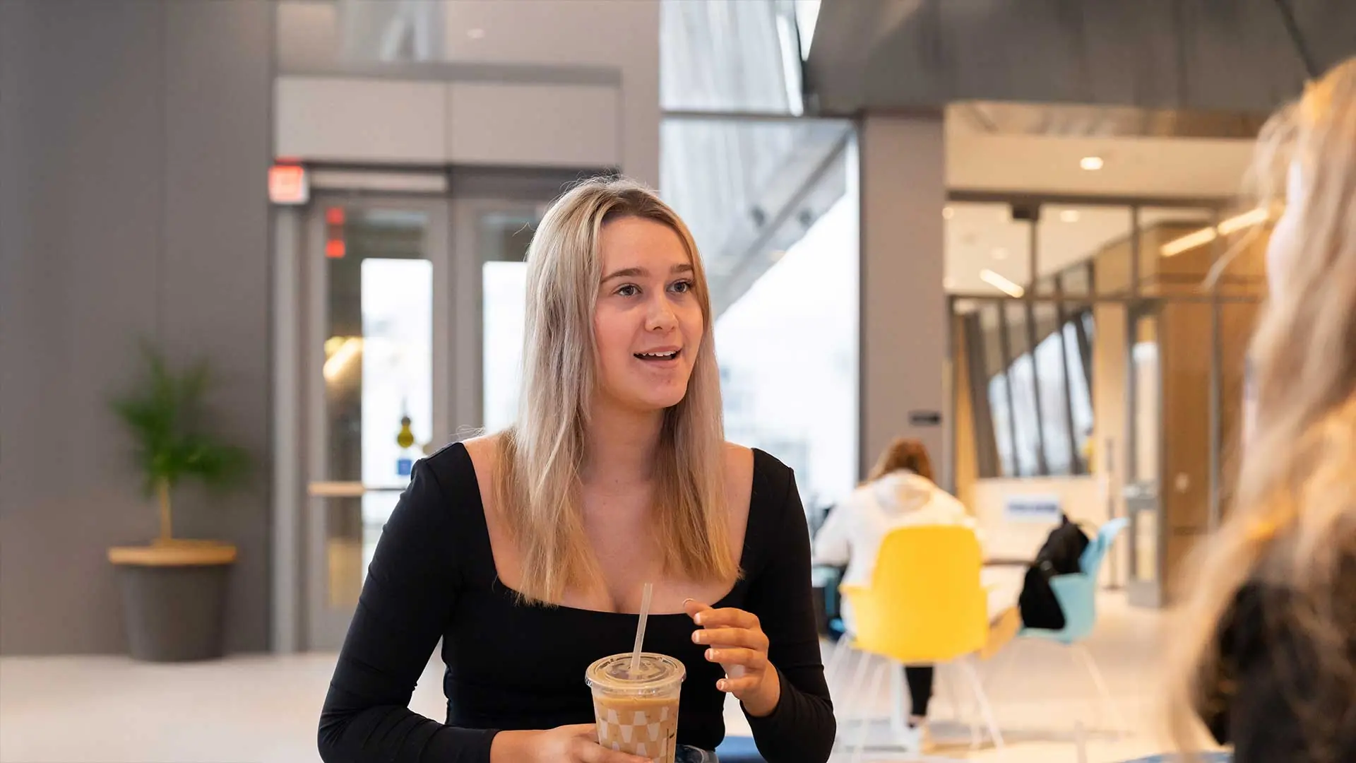 Student drinking an iced coffee and having a conversation